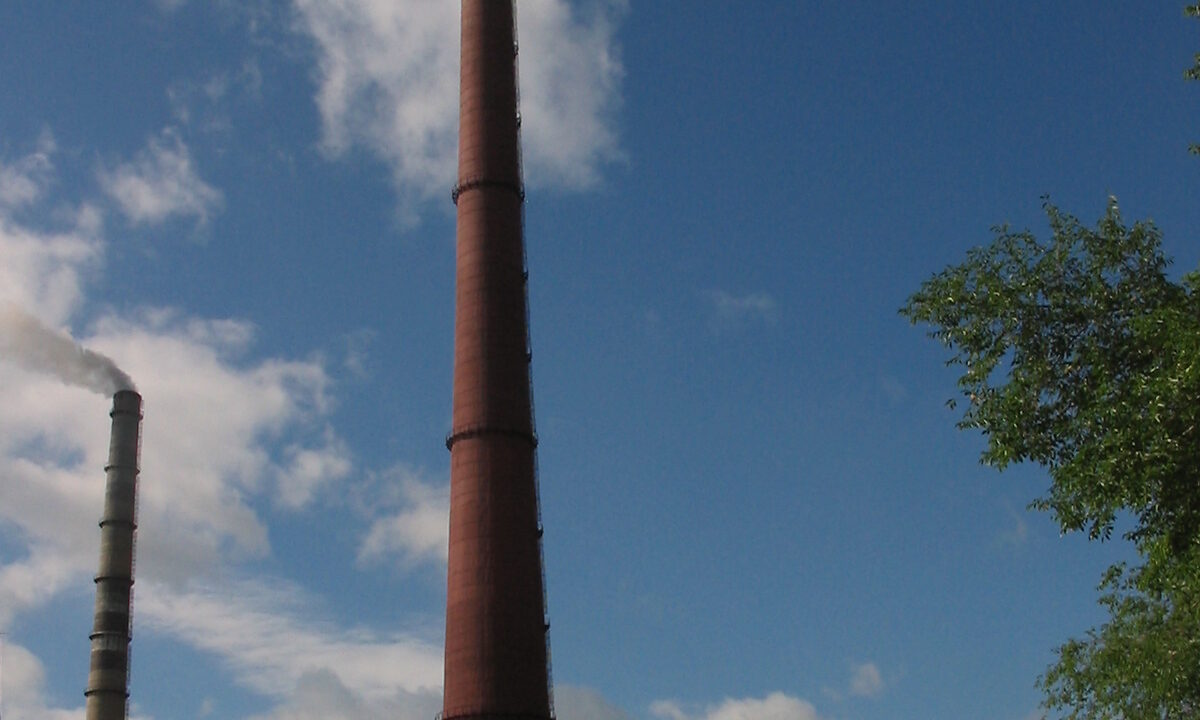 Industrial smokestacks emitting vapour into a clear sky